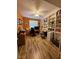 Well-lit home office with built-in bookshelves, an orange accent wall, and wood-look floors at 2267 Muir Ct, Henderson, NV 89052