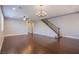 Spacious living room with hardwood floors, ceiling fan, decorative chandelier, and staircase at 2369 Via Barranca St, Henderson, NV 89044