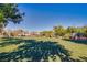 A beautiful community park featuring covered picnic areas, lush green grass, and mature trees on a clear sunny day at 2369 Via Barranca St, Henderson, NV 89044
