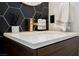 Close-up of modern bathroom sink featuring sleek fixtures and hexagon tile backsplash at 2750 Evolutionary Ln, Las Vegas, NV 89138