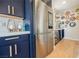 Gourmet kitchen features stainless refrigerator and custom cabinets with adjacent wet bar and custom wall decor at 2750 Evolutionary Ln, Las Vegas, NV 89138