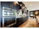 Modern kitchen featuring stainless steel appliances, white countertops, and custom dark blue cabinetry at 2750 Evolutionary Ln, Las Vegas, NV 89138