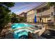 Beautiful pool area with a spa, lush landscaping, lounge chairs, and an outdoor living area at 2750 Evolutionary Ln, Las Vegas, NV 89138