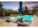 Outdoor pool and hot tub area with lounge chairs, mature trees and a privacy fence under a colorful sky at 2750 Evolutionary Ln, Las Vegas, NV 89138