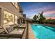 A private pool with lounge chairs, well manicured landscaping, and an outdoor kitchen and grill area at 2750 Evolutionary Ln, Las Vegas, NV 89138
