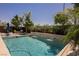 Inviting backyard pool with waterfall feature, mature trees, and a comfortable lounging area for relaxation and fun at 2750 Evolutionary Ln, Las Vegas, NV 89138