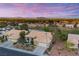 Beautiful single-story home with a beige tile roof, three-car garage and view of pond and Las Vegas skyline at 2820 High Range Dr, Las Vegas, NV 89134