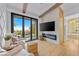 Luxurious bedroom with fireplace, TV, hardwood floors, patio access, and a connecting bathroom at 2820 High Range Dr, Las Vegas, NV 89134