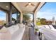 Relaxing outdoor patio with comfortable seating, a pizza oven, built-in grill, and lush landscaping overlooking the pool at 2820 High Range Dr, Las Vegas, NV 89134