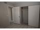 Neutral bedroom features a closet with sliding doors, an open door, and tile flooring at 3101 E Carey Ave, North Las Vegas, NV 89030