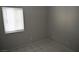 A simple bedroom features a window with blinds, tile floors, and neutral walls at 3101 E Carey Ave, North Las Vegas, NV 89030