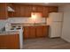 Cozy kitchen with wood cabinetry, double sink, white appliances, and modern flooring at 3101 E Carey Ave, North Las Vegas, NV 89030