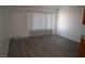 Sunlit living room featuring modern wood-look flooring and a large window with blinds at 3101 E Carey Ave, North Las Vegas, NV 89030
