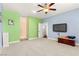 Spacious carpeted bedroom with blue and green walls, television, and a ceiling fan with light fixture at 3159 Via Como, Henderson, NV 89044