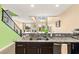 Contemporary kitchen with stainless steel appliances, dark cabinets, and granite countertops, with views of living space at 3159 Via Como, Henderson, NV 89044