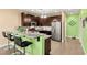 Modern kitchen featuring dark wood cabinets, stainless steel appliances and an island with bar stool seating at 3159 Via Como, Henderson, NV 89044