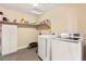 Bright laundry room with washer, dryer, and storage shelves at 3159 Via Como, Henderson, NV 89044