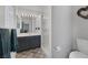 Bathroom with a blue vanity, patterned floor, glass block window and shower at 3481 Creek River Dr, Las Vegas, NV 89129