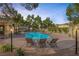 Relaxing community pool with shaded lounge area, well-maintained landscaping and privacy fencing at 3481 Creek River Dr, Las Vegas, NV 89129