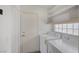 Functional laundry room with washer, dryer and storage shelving at 3481 Creek River Dr, Las Vegas, NV 89129