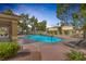 Inviting community pool area with lounge chairs, landscaping, and nearby residential buildings at 3481 Creek River Dr, Las Vegas, NV 89129