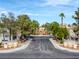 Scenic view of a tree-lined community entrance with landscaped medians and signage at 3481 Creek River Dr, Las Vegas, NV 89129
