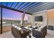 Stylish outdoor living space with comfortable seating, a fireplace, TV, and stunning views for evening relaxation at 358 Solitude Peak Ln, Henderson, NV 89012