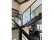 Staircase featuring wood treads and glass railing; a glimpse of the kitchen can be seen below at 358 Solitude Peak Ln, Henderson, NV 89012
