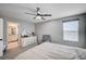 Relaxing bedroom featuring a ceiling fan, carpet, a window, and a view of an en suite bathroom at 4160 Elegant Chateau St, Las Vegas, NV 89135