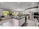Modern kitchen with an island, stainless steel appliances, and an open view to the living area at 4160 Elegant Chateau St, Las Vegas, NV 89135