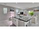 Spacious kitchen island with seating, modern lighting, and open layout to living area at 4160 Elegant Chateau St, Las Vegas, NV 89135