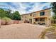 Expansive backyard featuring gravel, patio, outdoor seating, string lights, and a two-story home with a balcony at 4308 Desert Haven Ave, North Las Vegas, NV 89085