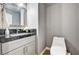 Powder room featuring a granite countertop, framed mirror, and modern toilet at 4308 Desert Haven Ave, North Las Vegas, NV 89085