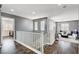 Hallway with dark floors and white railings, connecting living spaces with natural light at 4308 Desert Haven Ave, North Las Vegas, NV 89085