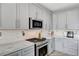 Modern kitchen features stainless steel appliances, marble countertops and backsplash, and gray cabinetry at 4308 Desert Haven Ave, North Las Vegas, NV 89085