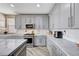 Modern kitchen with gray cabinets, stainless steel appliances, and marble countertops at 4308 Desert Haven Ave, North Las Vegas, NV 89085