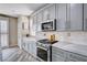 Modern kitchen features stainless steel appliances, marble countertops and backsplash, and gray cabinetry at 4308 Desert Haven Ave, North Las Vegas, NV 89085