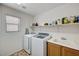 Functional laundry room featuring modern appliances, ample shelving, and a sink for added convenience at 4308 Desert Haven Ave, North Las Vegas, NV 89085