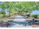 Scenic park walkway leading to a gazebo with picnic tables, surrounded by lush landscaping and mature trees at 4308 Desert Haven Ave, North Las Vegas, NV 89085