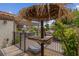 Backyard patio area with tiki-style umbrella, table, seating, plants, and a fenced area at 4326 Spooner Lake Cir, Las Vegas, NV 89147
