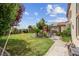 Landscaped backyard featuring mature palm trees, green lawn, and a brick walkway at 4326 Spooner Lake Cir, Las Vegas, NV 89147