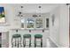 Inviting bar area with stylish pendant lighting, stools, and a view to the outdoor patio at 4326 Spooner Lake Cir, Las Vegas, NV 89147