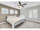 Neutral bedroom with a metal bed frame, ceiling fan and white shutters at 4326 Spooner Lake Cir, Las Vegas, NV 89147