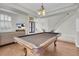 Open-concept game room with pool table, staircase, and large windows for natural light at 4326 Spooner Lake Cir, Las Vegas, NV 89147