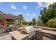 Outdoor kitchen and grill area with pergola covered dining space in landscaped backyard at 4326 Spooner Lake Cir, Las Vegas, NV 89147