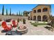 Spacious backyard featuring a fire pit, mature landscaping, and comfortable seating areas at 465 Cabral Peak St, Las Vegas, NV 89138