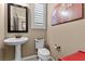 Cozy powder room featuring a pedestal sink, toilet, shutters and artwork above the toilet at 465 Cabral Peak St, Las Vegas, NV 89138