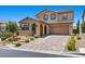 Two-story home featuring manicured landscaping, brick driveway, and a two-car garage at 465 Cabral Peak St, Las Vegas, NV 89138