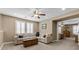 Relaxing living room with tan carpet, sectional sofa, shutters, ceiling fan, and a glimpse into the bedroom at 465 Cabral Peak St, Las Vegas, NV 89138