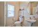 Clean powder room featuring pedestal sink, round mirror, and neutral decor at 4833 Straight Flush Dr # 103, Las Vegas, NV 89122